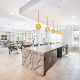 A spacious, modern kitchen and dining area with marble countertops and stylish pendant lighting.