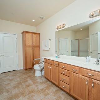 Spacious bathroom with a large vanity, mirror, and ample lighting.