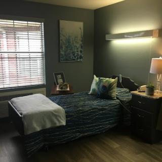 A cozy and modern bedroom featuring a neatly made bed, stylish decor, and warm lighting.