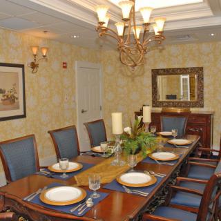 A formal dining room with an elegant table setting and chandelier.