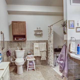 A tidy and well-equipped bathroom with a toilet, shower, and various accessories.