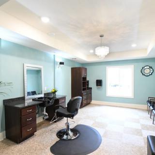 A modern and bright hair salon interior with stylish furniture and a large mirror.