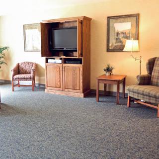 A cozy living room setup featuring comfortable seating, a television, and warm lighting.