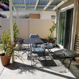 A sunny patio with outdoor furniture and potted plants.