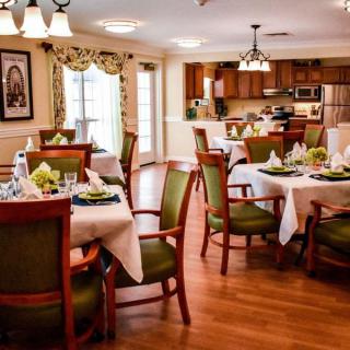 A beautifully decorated dining area with elegant table settings and a view of the kitchen.