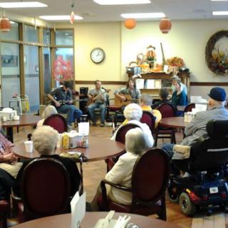 A group of musicians performing for elderly residents in a nursing home.