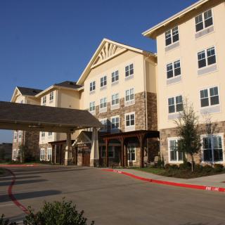 A modern senior living facility with a welcoming entrance and multiple floors.