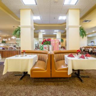 A well-lit restaurant interior featuring comfortable booths and neatly set tables.