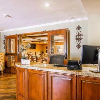 A warm and inviting hotel reception area featuring wooden furnishings.