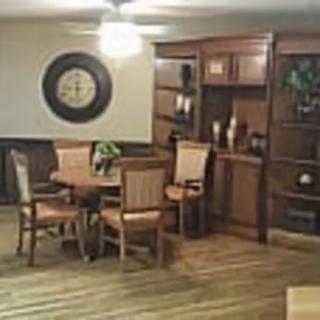 A cozy dining room with a wooden table, chairs, and a bookshelf.