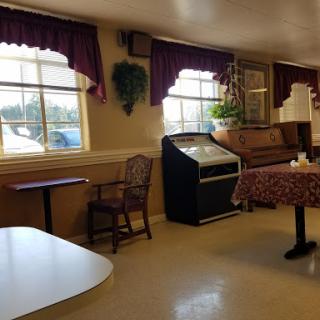 A cozy lobby area featuring seating arrangements, a vending machine, and natural light coming through the windows.