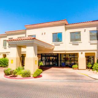 A sunny day view of a hotel exterior with a welcoming entrance.