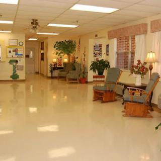 A spacious lobby with comfortable seating and plants, illuminated by overhead lighting.