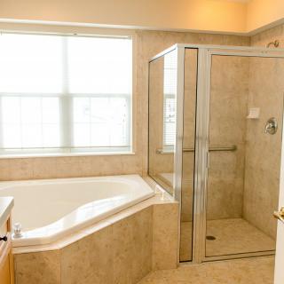 A modern bathroom featuring a separate bathtub and glass-enclosed shower.