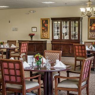Elegant dining area with neatly arranged tables and chairs, featuring a classic decor style.