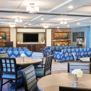 A stylish and comfortable lounge area with tables, chairs, and blue patterned couches.