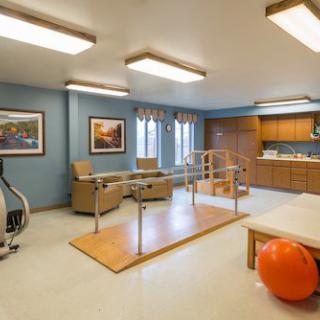 A rehabilitation room equipped with exercise equipment and a therapy ball.