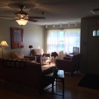 A cozy living room with comfortable seating and natural light from large windows.