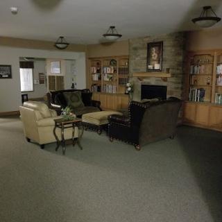 A cozy living room featuring a mix of comfortable seating and a bookshelf.