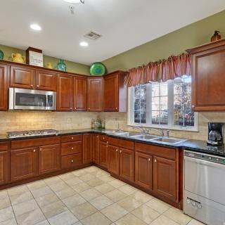 A spacious kitchen with wooden cabinets and modern appliances.