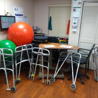 A therapy room equipped with various exercise tools including walkers and fitness balls.