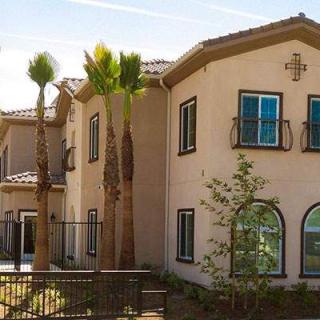 A residential building with palm trees in the foreground.