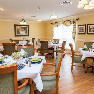 A cozy and elegantly decorated dining room with well-set tables and comfortable chairs.