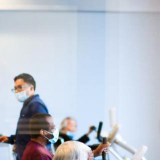 A group of people wearing masks in an indoor meeting setting.