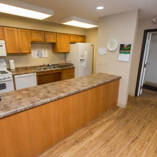 A modern kitchen featuring wooden cabinets, a countertop, and essential appliances.