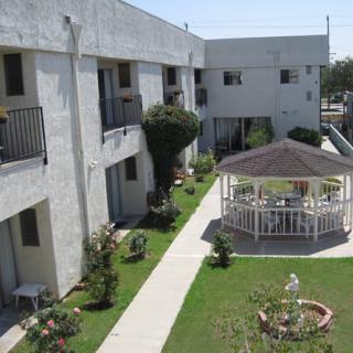 A residential building with a central courtyard featuring a gazebo and landscaped garden.