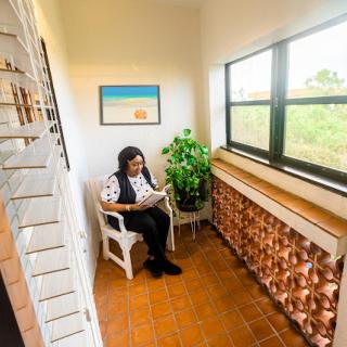 A cozy reading nook featuring a person enjoying a book in bright, natural light.