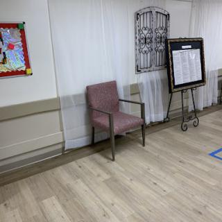 A quiet corner of a room featuring a chair and wall decor.