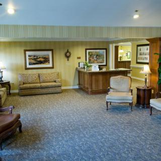 A cozy lobby area featuring sofas, chairs, and a reception desk.
