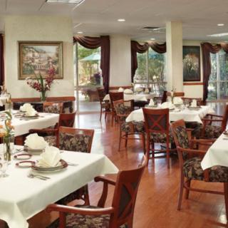 A sophisticated dining area with elegantly set tables and comfortable chairs, featuring classic interior decor.