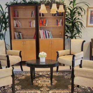 A cozy lounge area with comfortable chairs and a bookshelf, ideal for reading and relaxation.