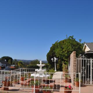 Front yard with a gated entrance and fountain on a clear day.