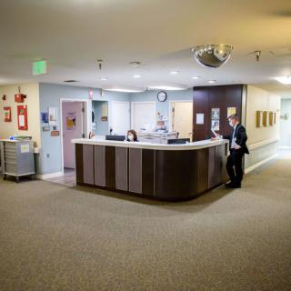 A hospital reception area with a front desk and corridor.