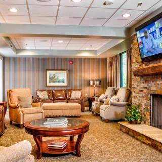 A cozy living room with comfortable seating, a fireplace, and a mounted television.
