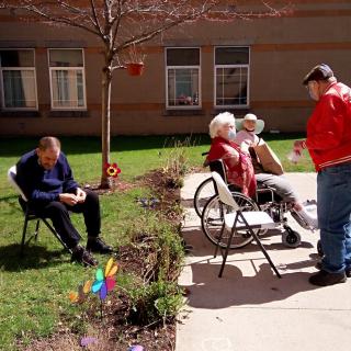 A group of seniors socializing outdoors on a sunny day.