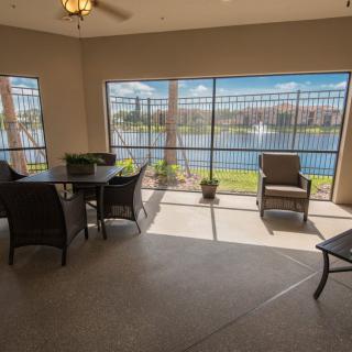 A bright patio with comfortable seating and a scenic lake view.