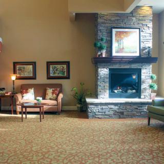 A cozy living room with a stone fireplace and comfortable seating.