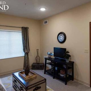 A cozy living room with a television, decor items, and a stylish clock.