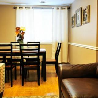 A cozy dining room with a wooden table, black chairs, and natural lighting.
