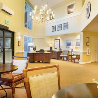 A spacious and elegantly designed lobby featuring a chandelier, reception desk, and comfortable seating.