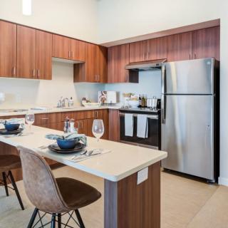 A modern kitchen with stainless steel appliances and a dining area.