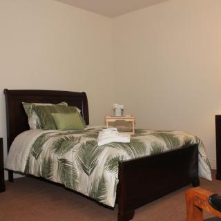 A neatly arranged bedroom with a bed and decorative bedding.