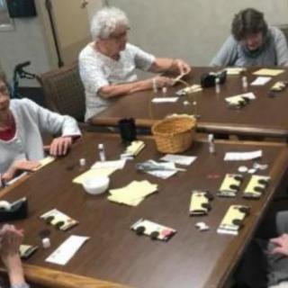 A group of seniors engaged in a crafting activity at a table.