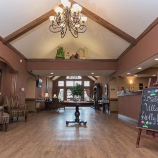 A welcoming lobby with a chandelier, wood flooring, and a seating area.