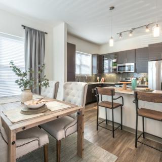 A modern open-concept kitchen and dining area featuring sleek furniture and elegant lighting.