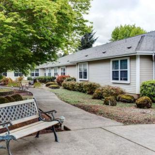 A peaceful outdoor space with a bench and landscaped walkway alongside residential buildings.